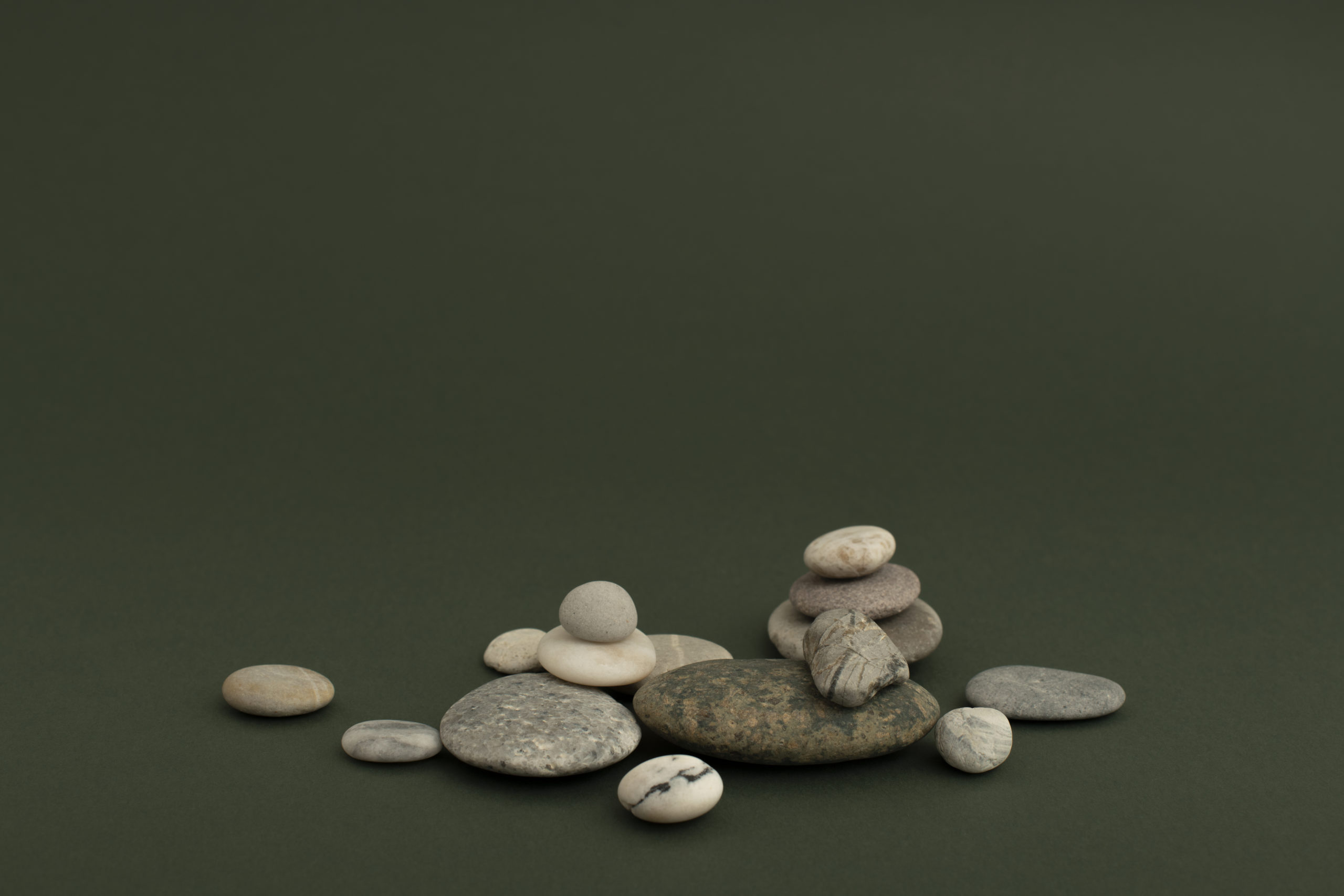 Marble zen stones stacked on green background in health and wellbeing concept